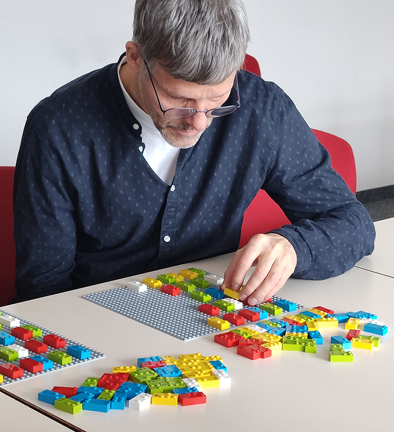 BFW-Mitarbeiter beim bei praktischen Übungen mit Braille-Lego-Steinen