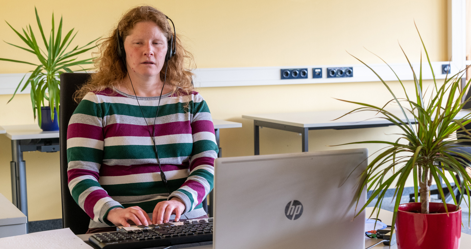 Foto Teilnehmerin am Notebook mit Braillezeile