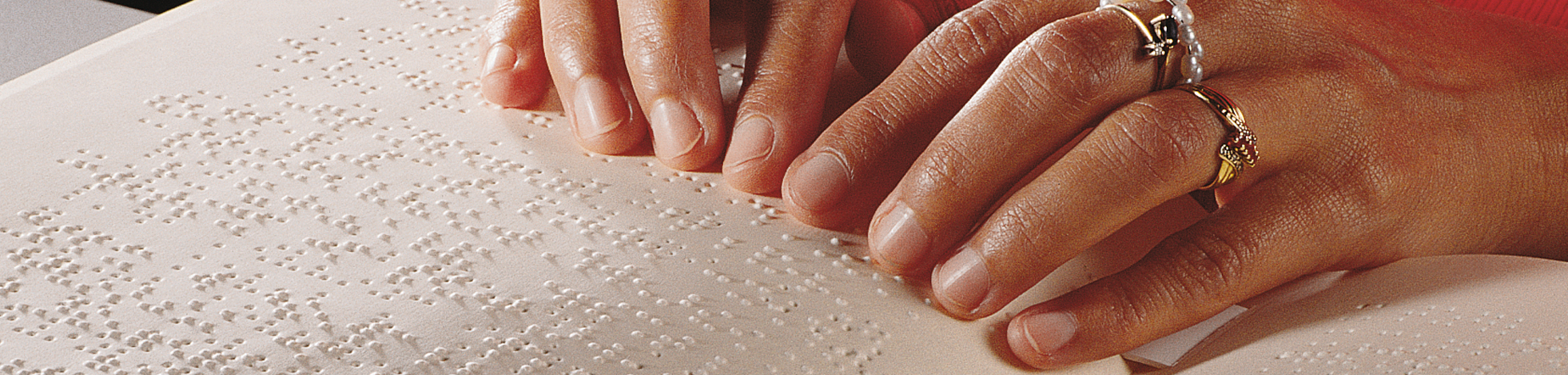 Foto Hände, die ein Brailleheft lesen