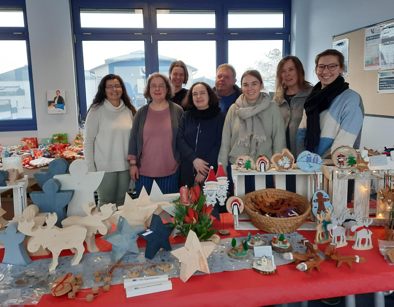 Die Teilnehmerinnen desUnterrichtsprojekts mit ihren Ausbilderinnen am Verkaufsstand beim Weihnachtsbasar Die Teilnehmerinnen desUnterrichtsprojekts mit ihren Ausbilderinnen am Verkaufsstand beim Weihnachtsbasar